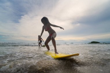 Pattaya, Tayland 'da sörf tahtasıyla sahilde sörf yapan mutlu çift..