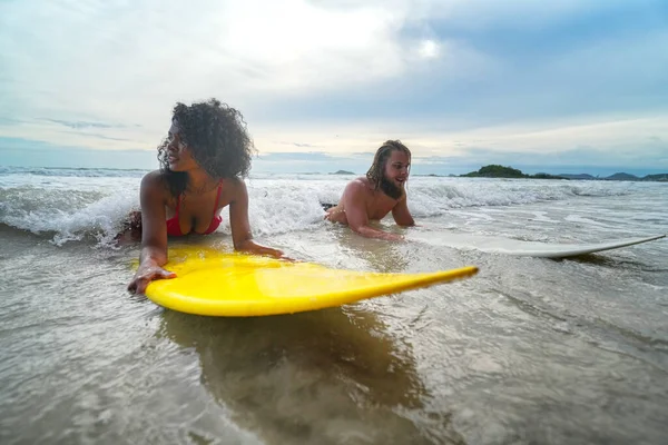 Pattaya, Tayland 'da sörf tahtasıyla sahilde sörf yapan mutlu çift..