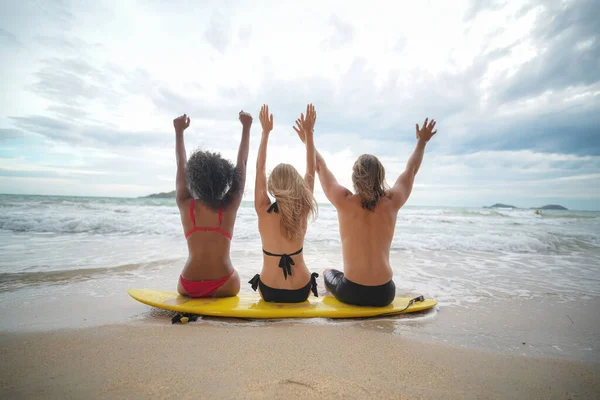 年轻的女性和男性冲浪者在海滩享受时光 — 图库照片