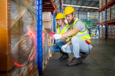 Depo çalışanları perakende deposundaki stokları ve envanterleri kontrol ediyor. İş fabrikası endüstrisi kavramı.