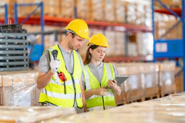 Depo işçileri perakende deposundaki stokları ve envanterleri kontrol ediyor. İş fabrikası endüstrisi kavramı.