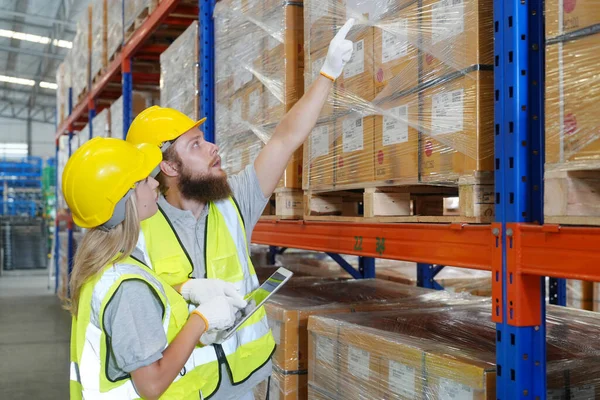 倉庫内部産業サプライチェーンと物流会社 倉庫労働者が在庫を確認 在庫棚の製品 — ストック写真