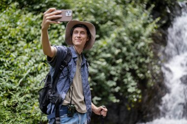 Gençler fotoğraf çekiyor, ormanda yürüyüş yaparken eğleniyorlar.