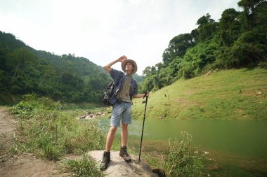 Yürüyüşçüler dağda yürüyüş sopalarıyla bir patika boyunca yürüyorlar. Macera, seyahat, turizm, yürüyüş ve insan konsepti. Sırt çantalı bir grup gülen arkadaş..