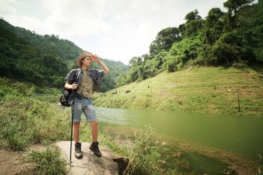 Yürüyüşçüler dağda yürüyüş sopalarıyla bir patika boyunca yürüyorlar. Macera, seyahat, turizm, yürüyüş ve insan konsepti. Sırt çantalı bir grup gülen arkadaş..