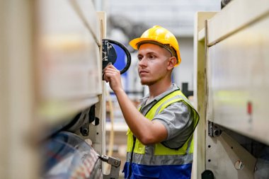 Fabrikada sanayi işçisi. Sert şapkalı genç teknisyen. Akıllı fabrika işçisi başlık takıyor ve elektrik santralinde çalışıyor.