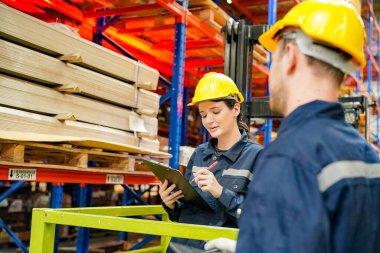 Depo Endüstriyel tedarik zinciri ve lojistik şirketleri içeride. Depo çalışanları envanteri kontrol ediyor. Envanter raflarındaki ürünler. Depoda envanter yapan bir işçi. Üniformalı bir görevli depoda envanter çıkarıyor. tedarik zinciri