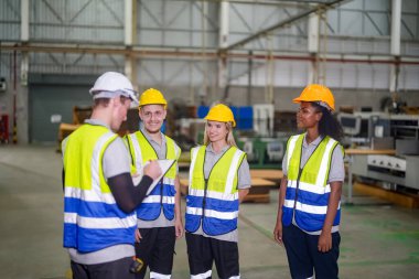 Lojistik dağıtım deposunda birlikte duran bir grup gülen işçi, takım çalışması konsepti