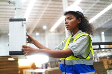 Fabrikada sanayi işçisi. Turuncu şapkalı genç teknisyen. Kafkasyalı akıllı fabrika işçisi başlık takıyor ve elektrik santralinde çalışıyor..