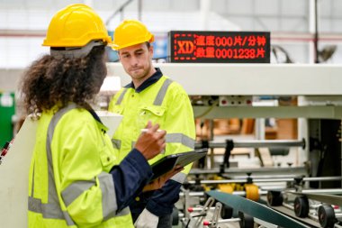 Fabrikada sanayi işçisi. Turuncu şapkalı genç teknisyen. Kafkasyalı akıllı fabrika işçisi başlık takıyor ve elektrik santralinde çalışıyor..