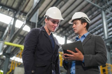 Demiryolu mühendisliği tesisinde lokomotifi inceleyen mühendisler