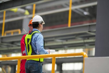 Demiryolu mühendisliği atölyesinde mühendis ve çırak portresi.