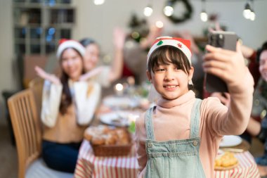 Güzel mutlu aile masanın etrafında toplanmış, Noel yemeği yiyor, kış tatilinin tadını çıkarıyor ve birlikte vakit geçiriyorlar.