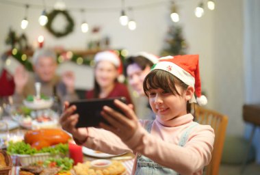 Güzel mutlu aile masanın etrafında toplanmış, Noel yemeği yiyor, kış tatilinin tadını çıkarıyor ve birlikte vakit geçiriyorlar.