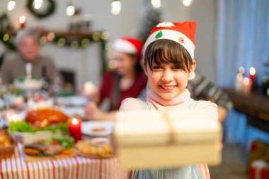 Güzel mutlu aile masanın etrafında toplanmış, Noel yemeği yiyor, kış tatilinin tadını çıkarıyor ve birlikte vakit geçiriyorlar.