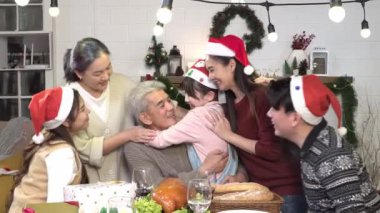 Asyalı aile Noel 'i birlikte kutluyor. Noel masasında kucaklaşmak