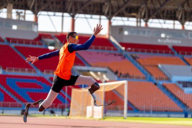 Stadyumdaki koşu pistinde protez bıçaklı Asyalı sporcular.