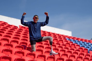 Stadyumdaki koşu pistinde protez bıçaklı Asyalı sporcular.