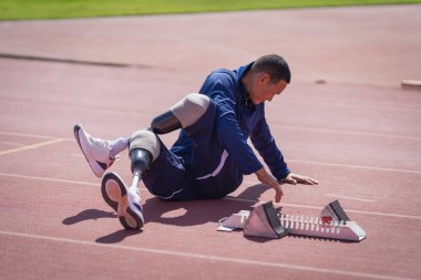 Stadyumdaki koşu pistinde protez bıçaklı Asyalı sporcular.