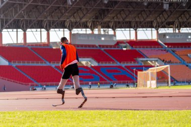 Stadyumdaki koşu pistinde protez bıçaklı Asyalı sporcular.