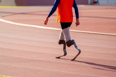 Stadyumdaki koşu pistinde protez bıçaklı Asyalı sporcular.