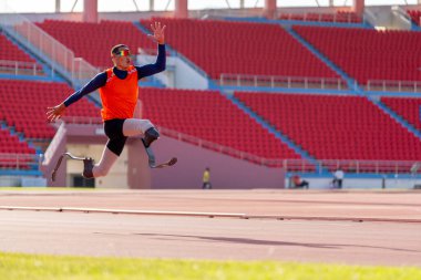 Stadyumdaki koşu pistinde protez bıçaklı Asyalı sporcular.