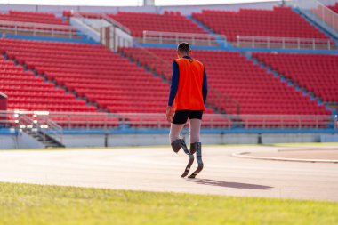 Stadyumdaki koşu pistinde protez bıçaklı Asyalı sporcular.