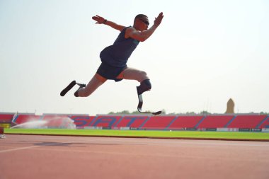 Stadyumdaki koşu pistinde protez bıçaklı Asyalı sporcular.