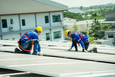 Profesyonel mühendisler güneş ışığı altında güneş çatılarını kontrol ediyorlar. Elektrik yenilenebilir enerji hizmeti veren mühendisler