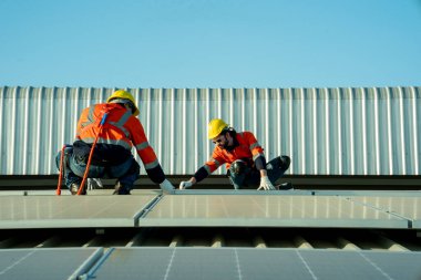 Profesyonel mühendisler güneş ışığı altında güneş çatılarını kontrol ediyorlar. Elektrik yenilenebilir eko enerji hizmeti veren mühendisler