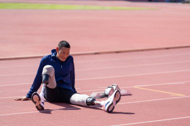 Stadyumdaki koşu pistinde protez bıçaklı Asyalı sporcular.