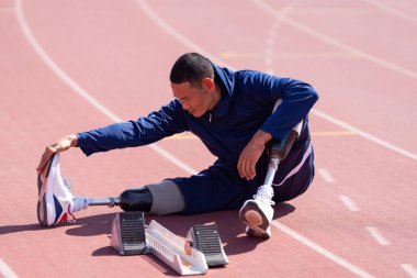 Stadyumdaki koşu pistinde protez bıçaklı Asyalı sporcular.