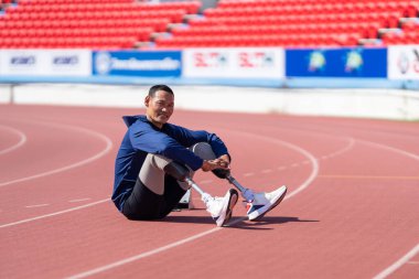 Stadyumdaki koşu pistinde protez bıçaklı Asyalı sporcular.