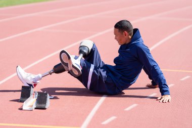 Stadyumdaki koşu pistinde protez bıçaklı Asyalı sporcular.