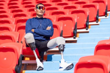 Stadyumdaki koşu pistinde protez bıçaklı Asyalı sporcular.