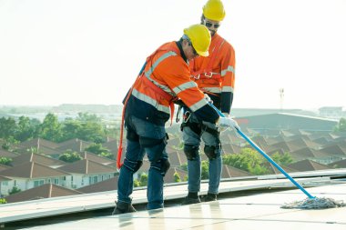 Profesyonel mühendisler güneş ışığı altında güneş çatılarını kontrol ediyorlar. Elektrik yenilenebilir eko enerji hizmeti veren mühendisler