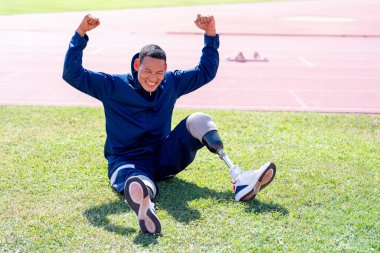 Stadyumdaki koşu pistinde protez bıçaklı Asyalı sporcular.