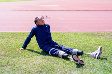 Stadyumdaki koşu pistinde protez bıçaklı Asyalı sporcular.