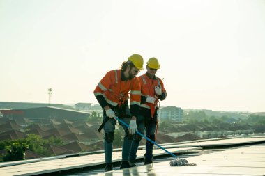 Profesyonel mühendisler güneş ışığı altında güneş çatılarını kontrol ediyorlar. Elektrik yenilenebilir eko enerji hizmeti veren mühendisler