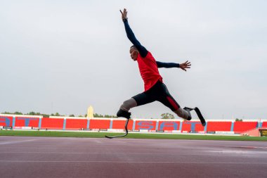 Stadyumdaki koşu pistinde protez bıçaklı Asyalı sporcular.