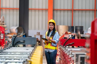 Fabrikada koruyucu giysili bir kadın. Makinede kendine güvenen kadın mühendis.