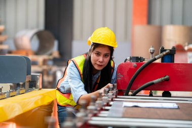 Fabrikada koruyucu giysili bir kadın. Makinede kendine güvenen kadın mühendis.