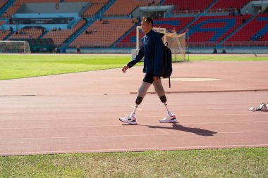 Stadyumdaki koşu pistinde protez bıçaklı Asyalı sporcular.