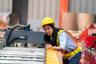 Fabrikada koruyucu giysili bir kadın. Makinede kendine güvenen kadın mühendis.