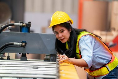 Fabrikada koruyucu giysili bir kadın. Makinede kendine güvenen kadın mühendis.