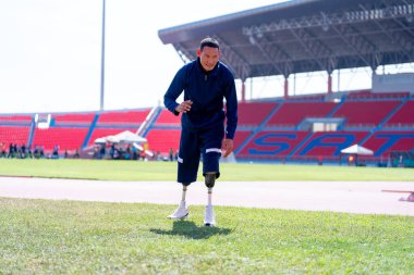 Stadyumdaki koşu pistinde protez bıçaklı Asyalı sporcular.