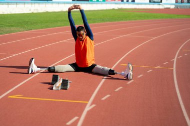 Stadyumdaki koşu pistinde protez bıçaklı Asyalı sporcular.