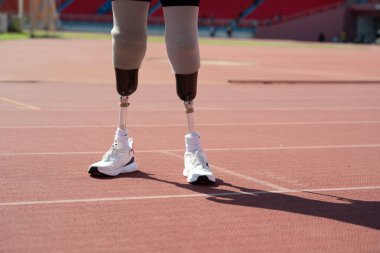 Stadyumdaki koşu pistinde protez bıçaklı Asyalı sporcular.