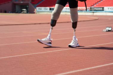 Protez bıçaklı Asyalı sporcular stadyumdaki koşu pistinde koşuyorlar..