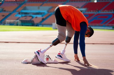 Stadyumdaki koşu pistinde protez bıçaklı Asyalı sporcular.